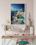 Modern home office with a desk, chair, lamp, and decorative items including a large framed picture of a pool.