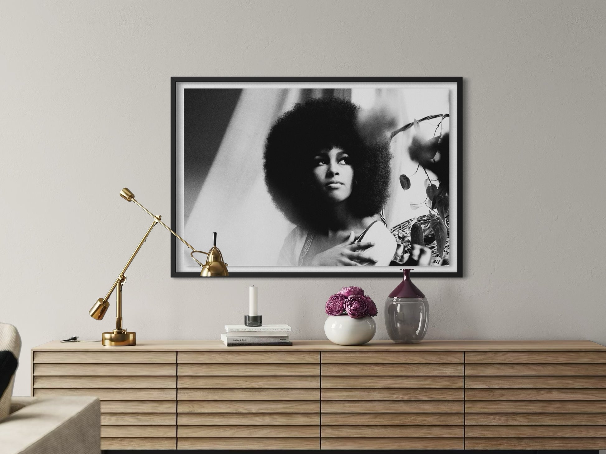 Framed black and white portrait on a wall above a wooden console table with decorative items.