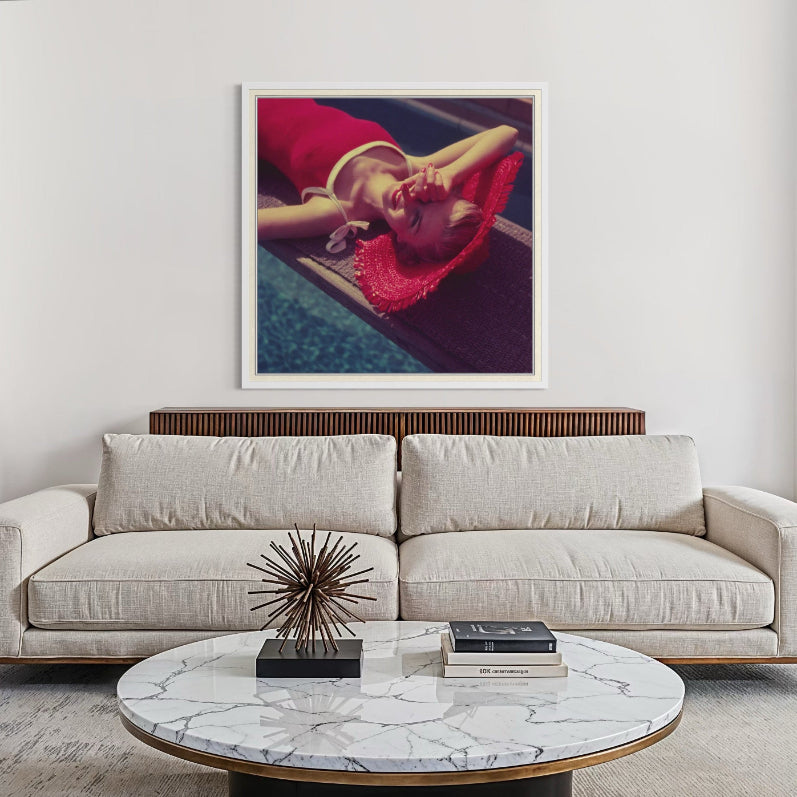 Modern living room with a beige sofa, marble coffee table, and framed artwork on the wall.
