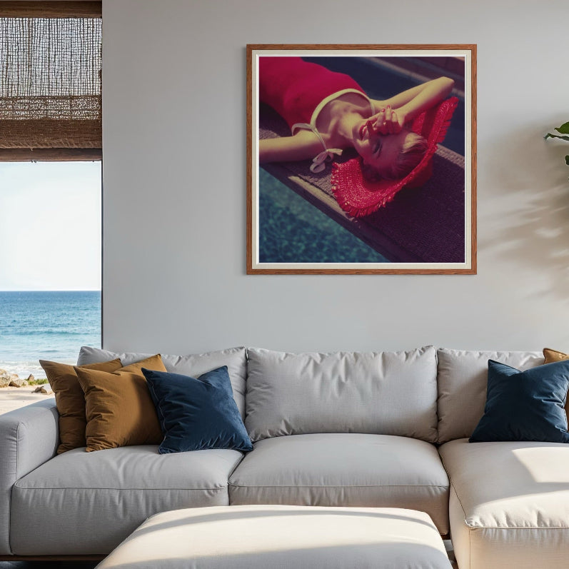 Modern living room with a gray sectional sofa, decorative pillows, and a framed artwork of a woman in a red dress.