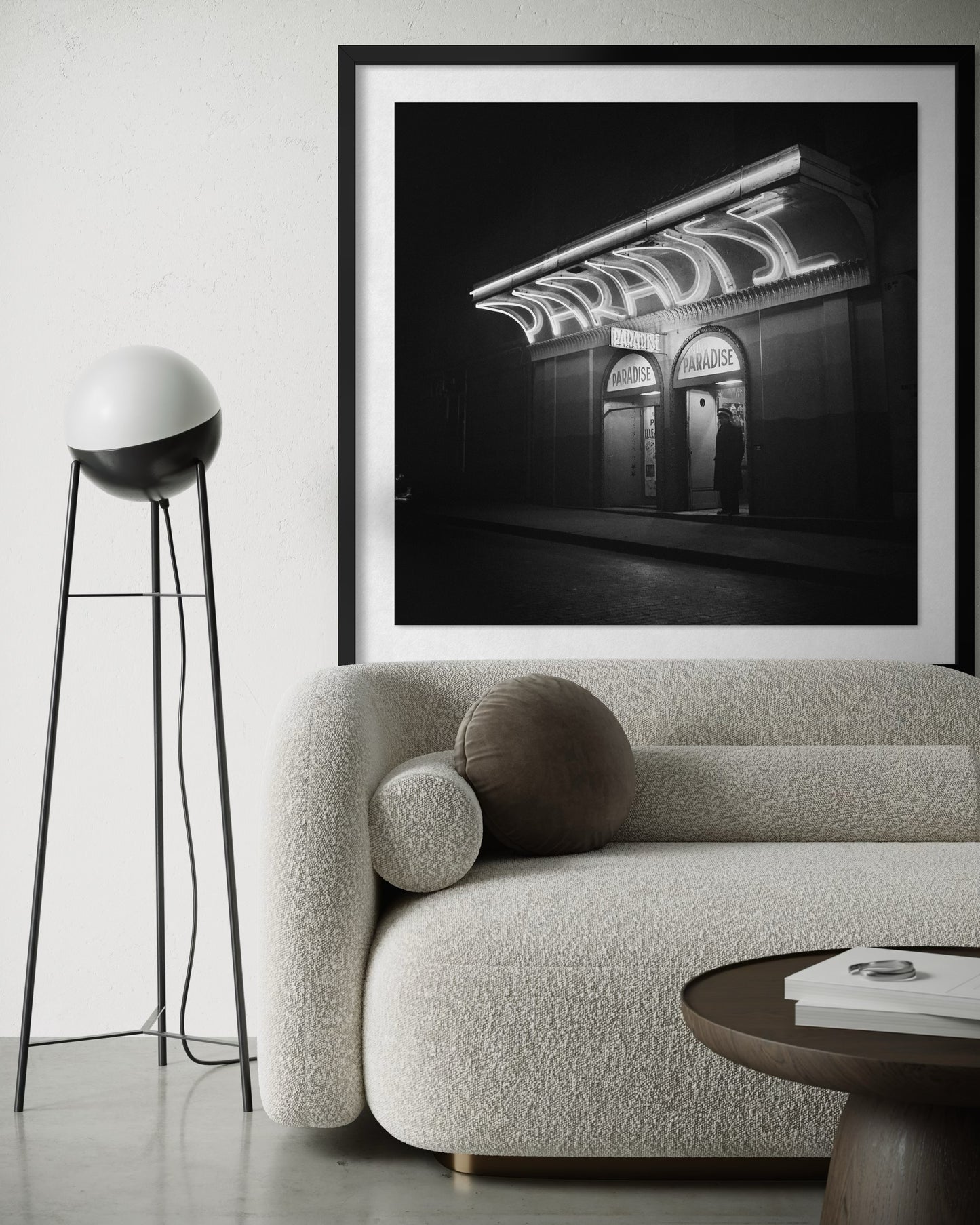 Framed black and white photograph of a building with 'Paradise' sign above a modern living room.