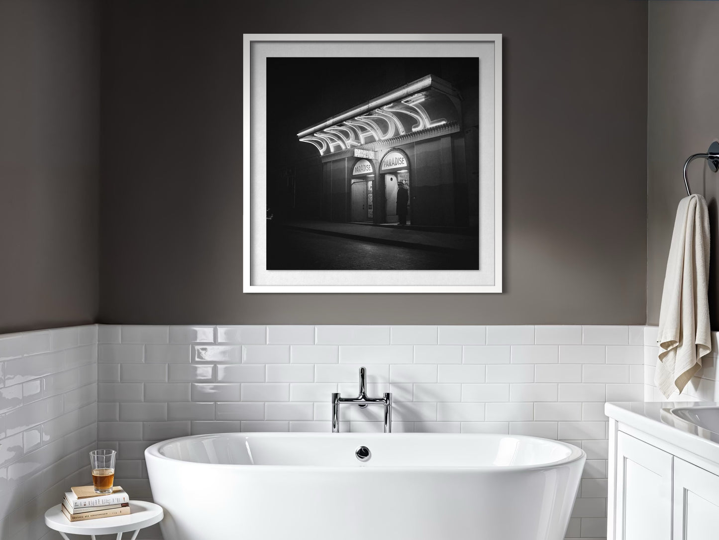 Bathroom interior with a framed black and white photograph above a freestanding bathtub.