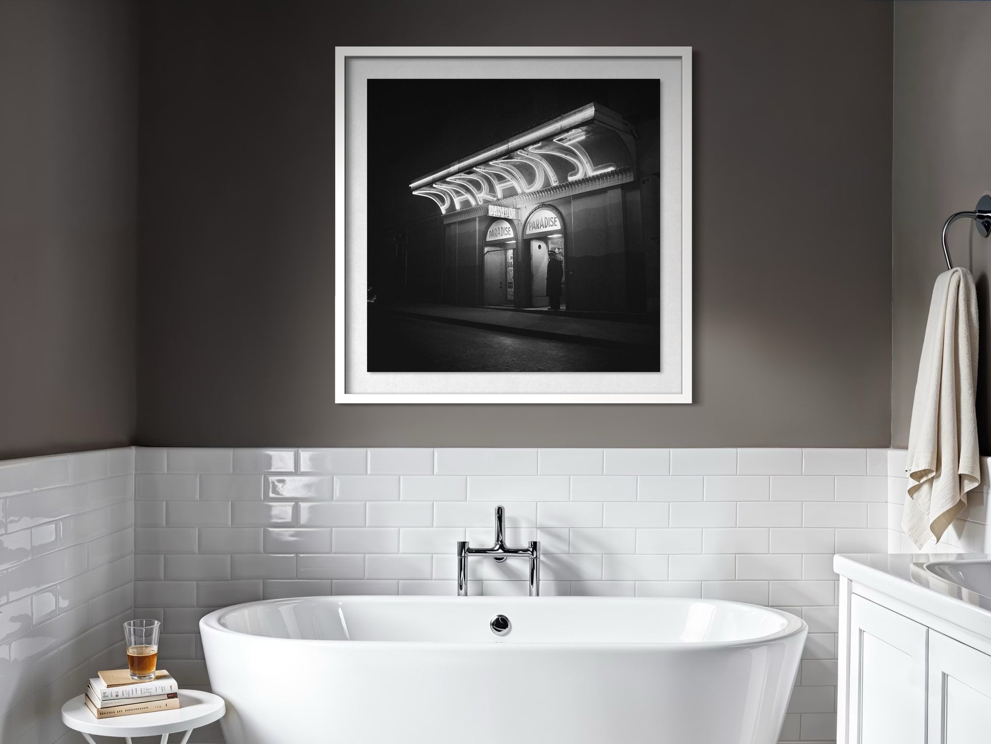 Bathroom interior with a framed black and white photograph above a freestanding bathtub.