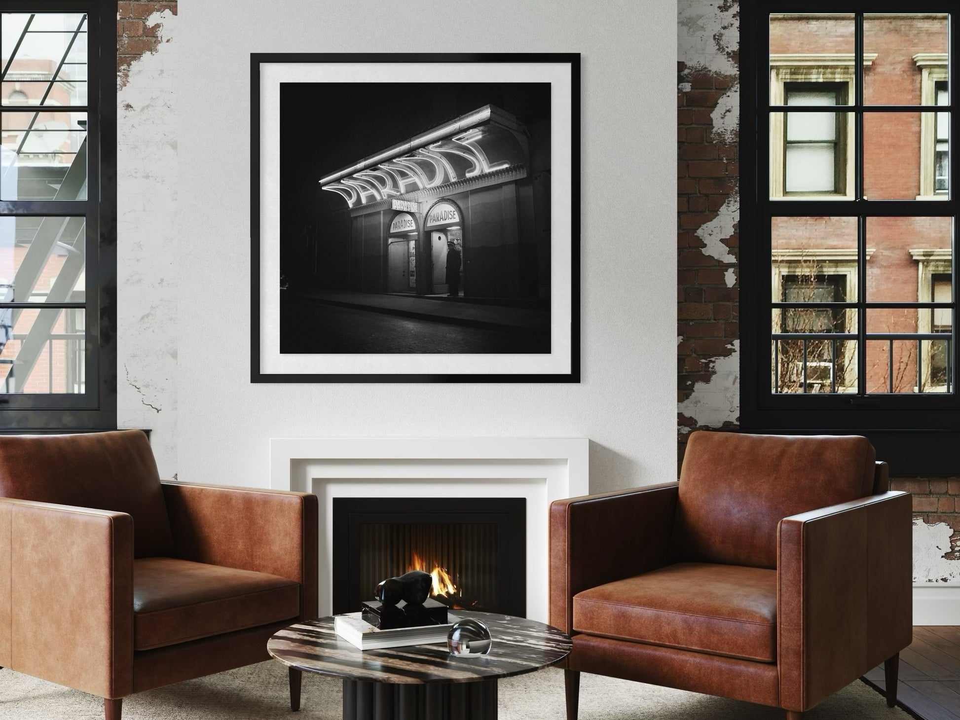 Living room with brown leather chairs, a fireplace, and framed artwork on the wall.