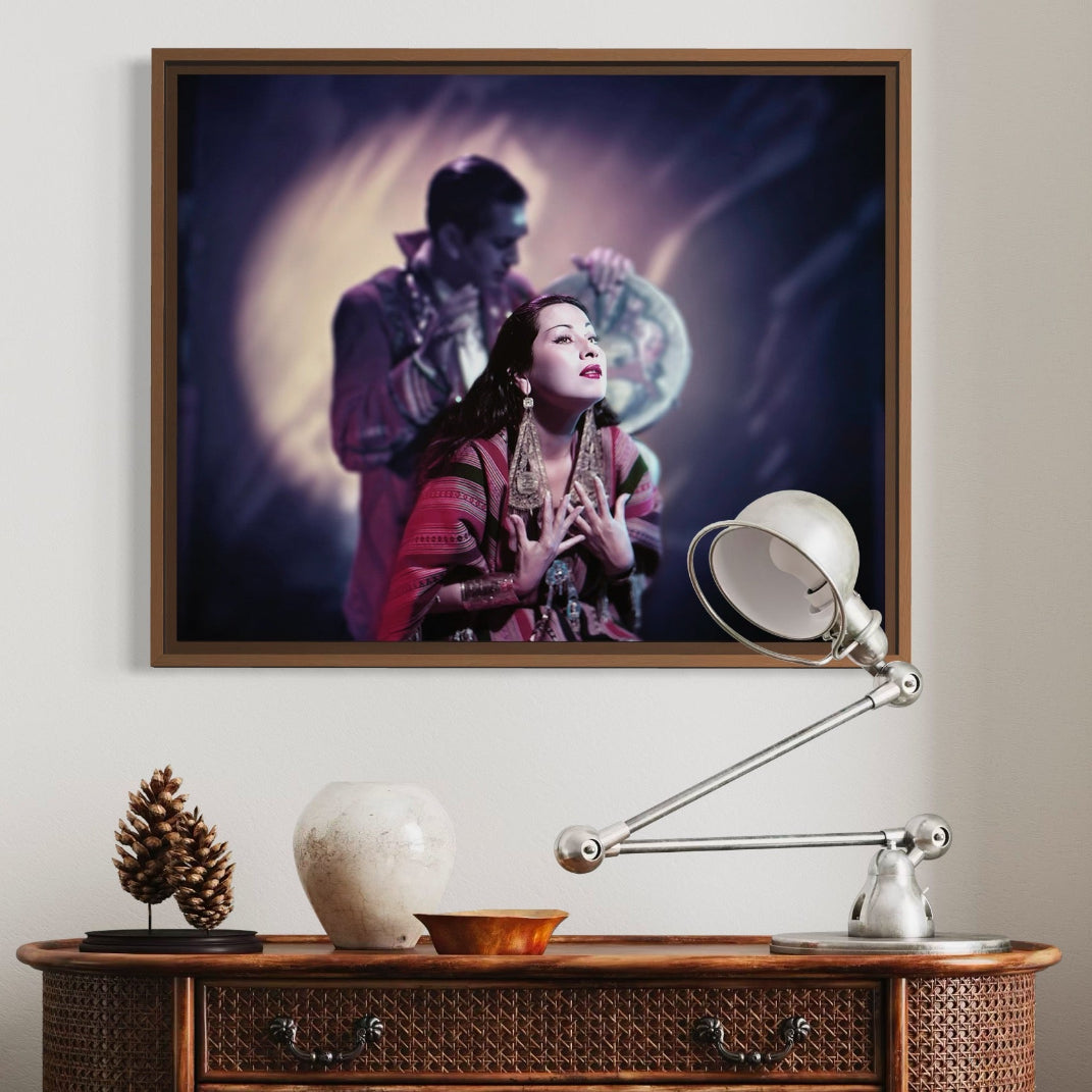 Framed artwork of a couple on a wall above a wooden console table with decorative items.
