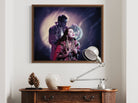 Framed artwork of a couple on a wall above a wooden console table with decorative items.