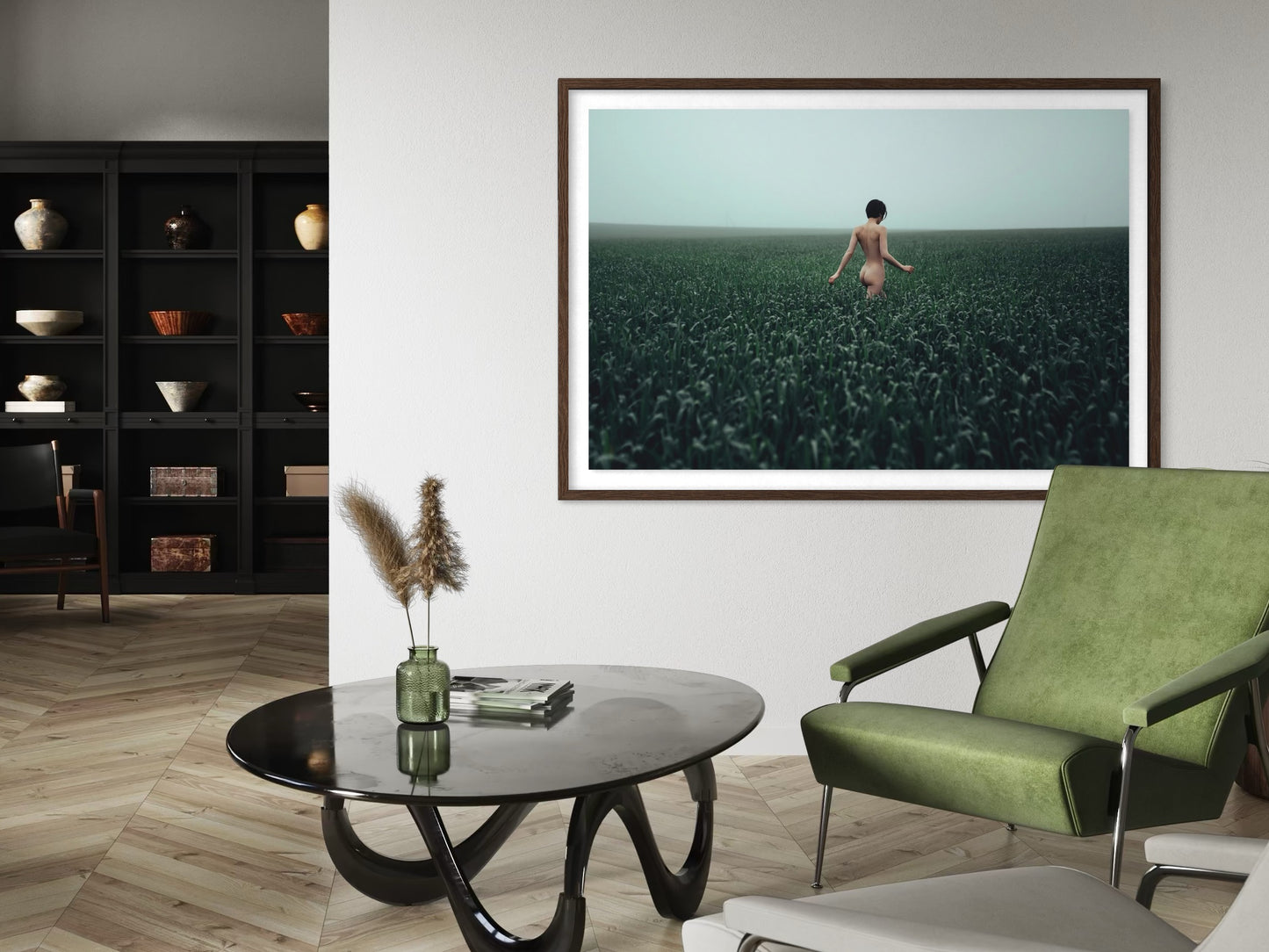Modern living room with a green armchair, round black coffee table, and a large framed picture of a person in a field.