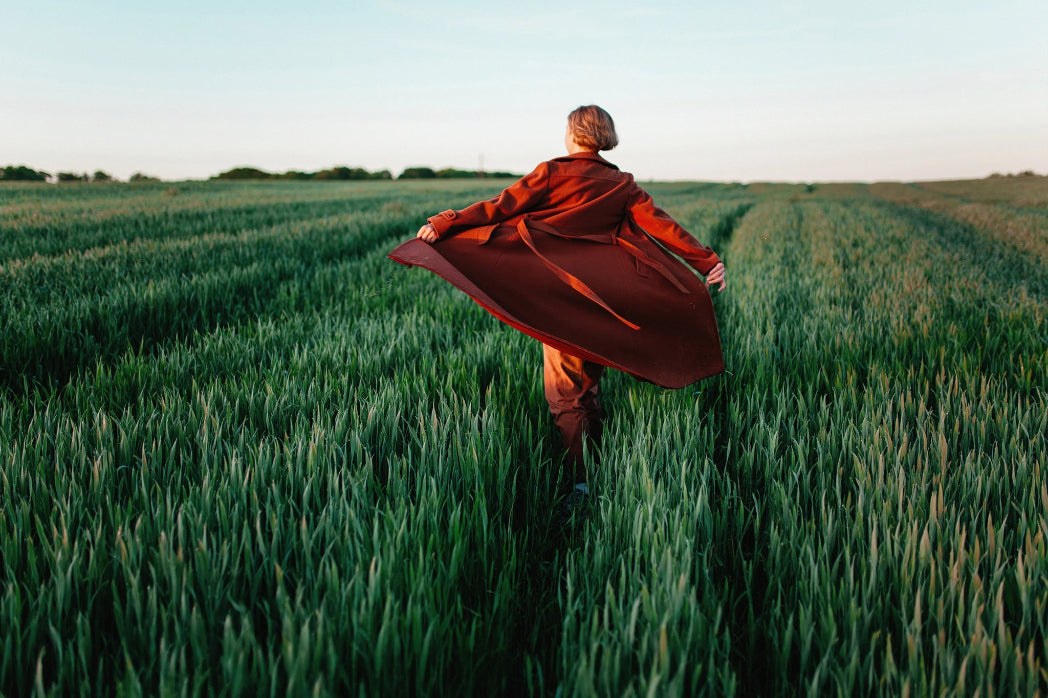 A person walking through a green field at sunset in Walking at Sunset by Igor Ustynskyy for Getty Images, offered by The Picturalist as fine art prints USA and framed prints Canada, ideal for luxury art procurement, bespoke wall art solutions, and high-end interior design art.