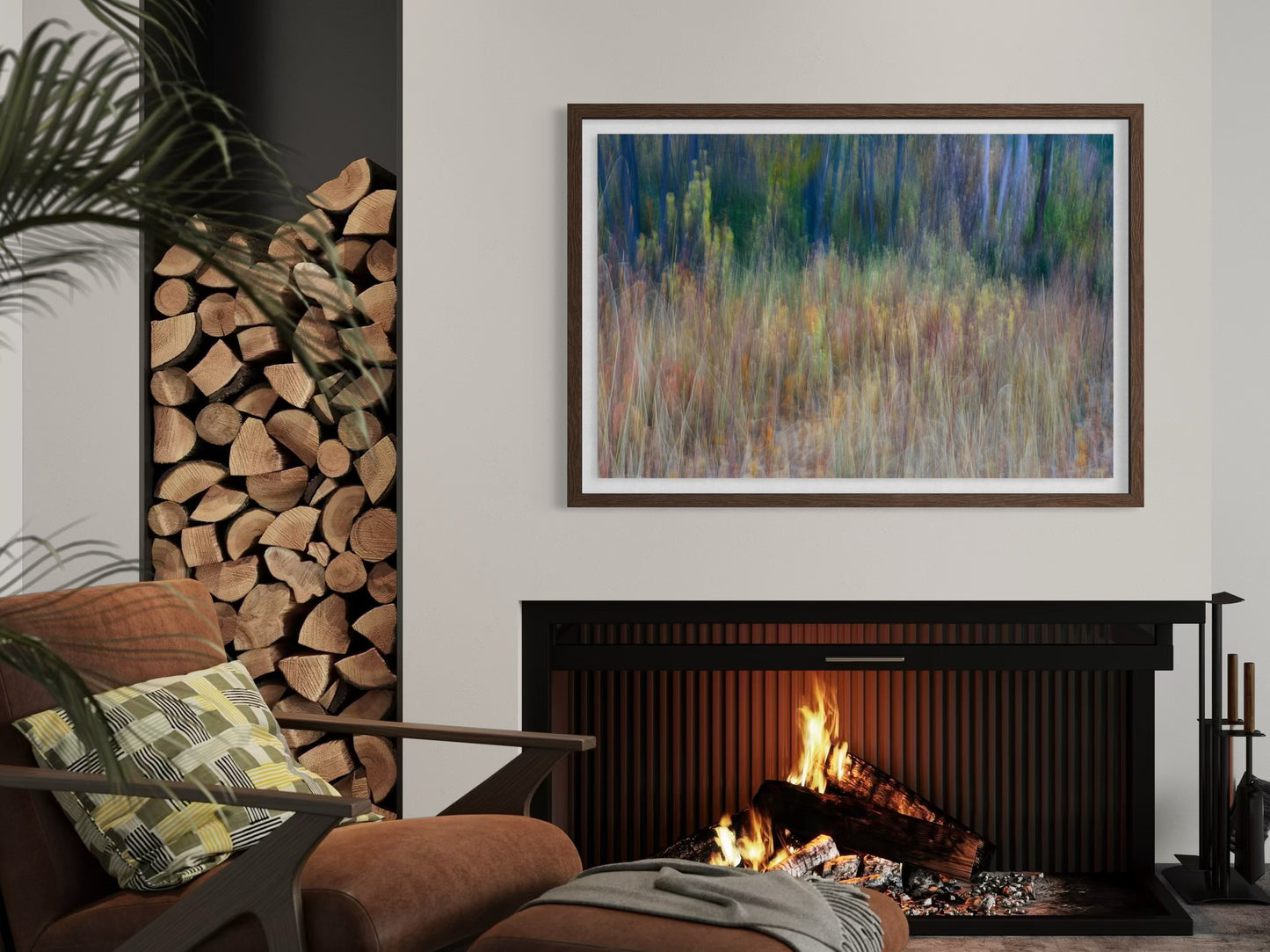 Living room with a fireplace, stacked logs, and a framed abstract photograph.