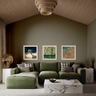A styled living room featuring a large olive green sectional sofa with matching pillows, a white marble coffee table, and three framed landscape art prints on a dark olive green wall.