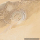 Aerial satellite photograph of a circular salt flat or desert formation surrounded by sandy terrain, with pale beige and tan tones throughout.