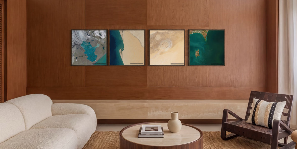 A modern living room with a large cream boucle sofa, a round wooden coffee table, a dark wood armchair, and a warm wood-paneled wall featuring a four-panel abstract canvas print.