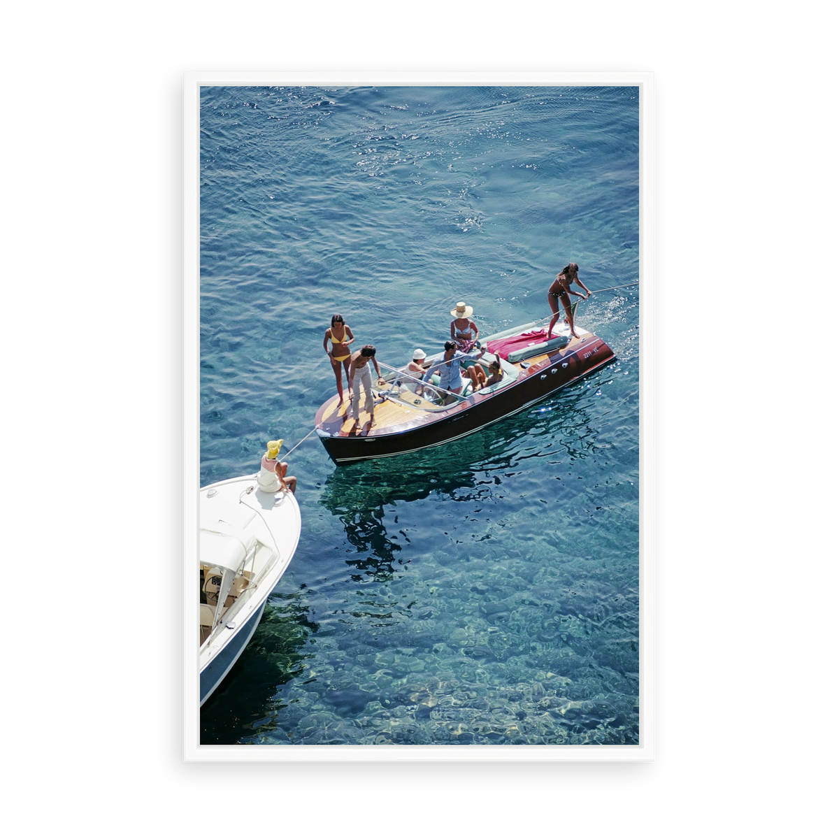 Illustrative matte-white floater-framed preview, without added mat, of Riva in Porto Ercole by Slim Aarons. Proportions vary by size.
