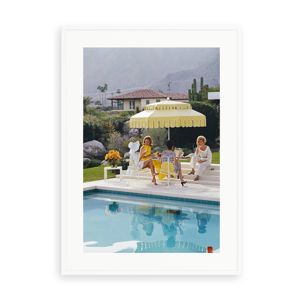 Illustrative matte-white framed preview with white inner border of Nelda and Friends by Slim Aarons. Proportions vary by size.