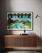 Framed artwork of a pool scene on a wall above a wooden cabinet.