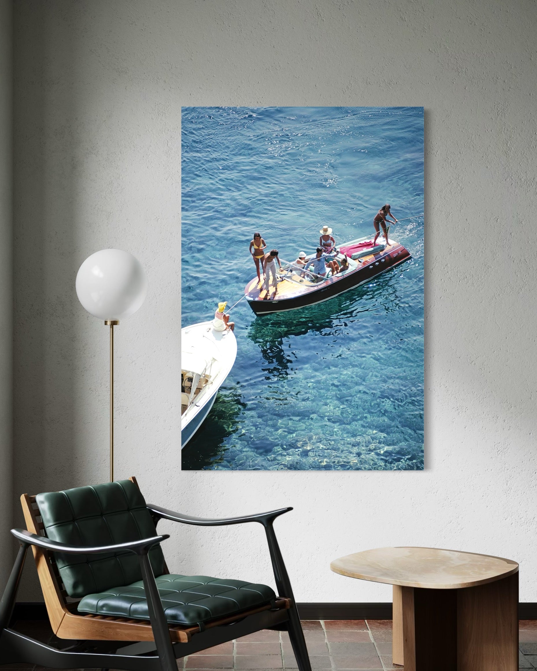 Canvas print of people on a boat hanging on a wall above a chair.