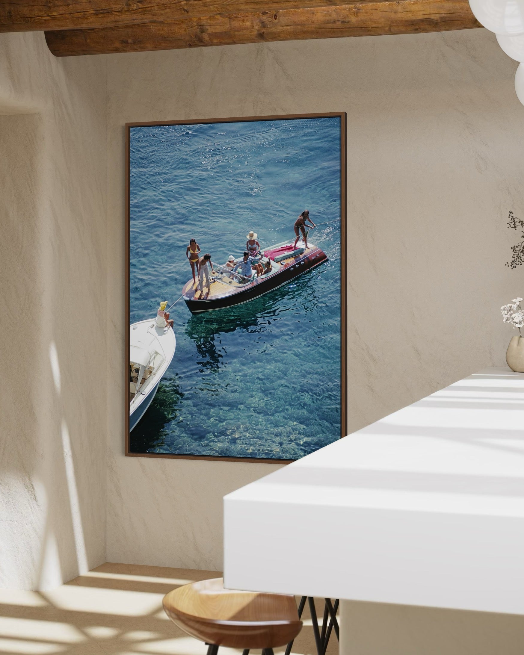 Framed photograph of people on a boat in the water, hanging on a wall.