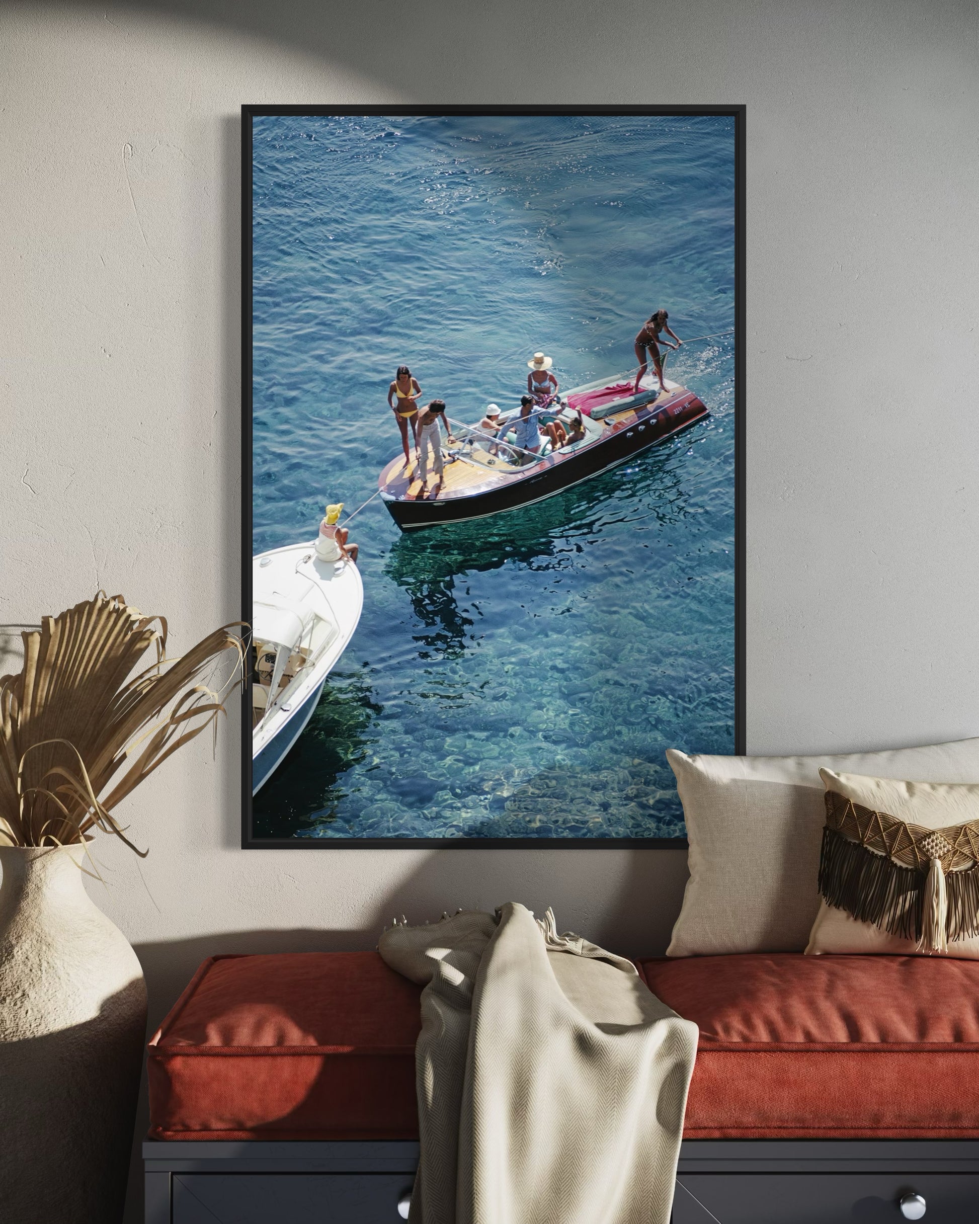 Framed photograph of people on a boat in the water, hanging on a wall above a sofa.