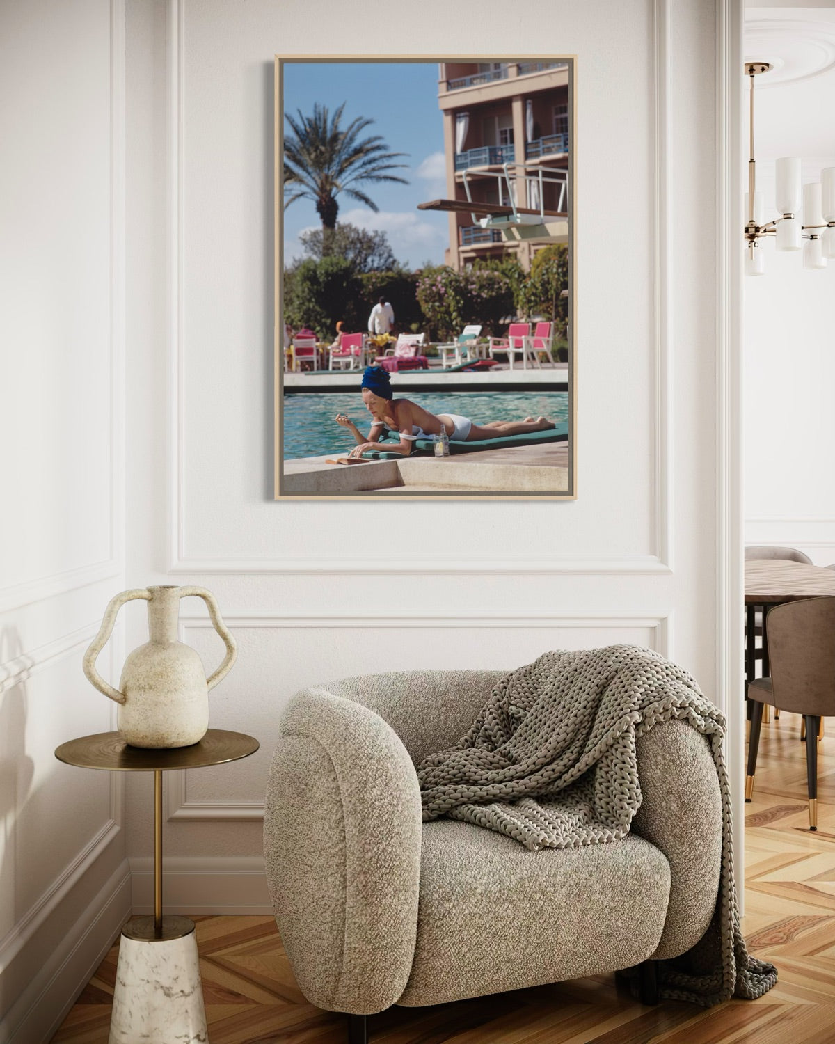 Living room with a beige armchair, side table, and Poolside in Marrakesh Morocco by Slim Aarons featuring elegant resort leisure and Moroccan architecture in a luxury poolside setting.