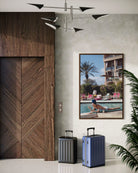 Two suitcases in a modern interior setting with a wooden door and Poolside in Marrakesh Morocco by Slim Aarons featuring elegant resort leisure and Moroccan architecture in a luxury poolside setting.