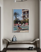 Framed artwork of Poolside in Marrakesh Morocco by Slim Aarons featuring elegant resort leisure and Moroccan architecture in a luxury poolside setting, on a wall above a bench.