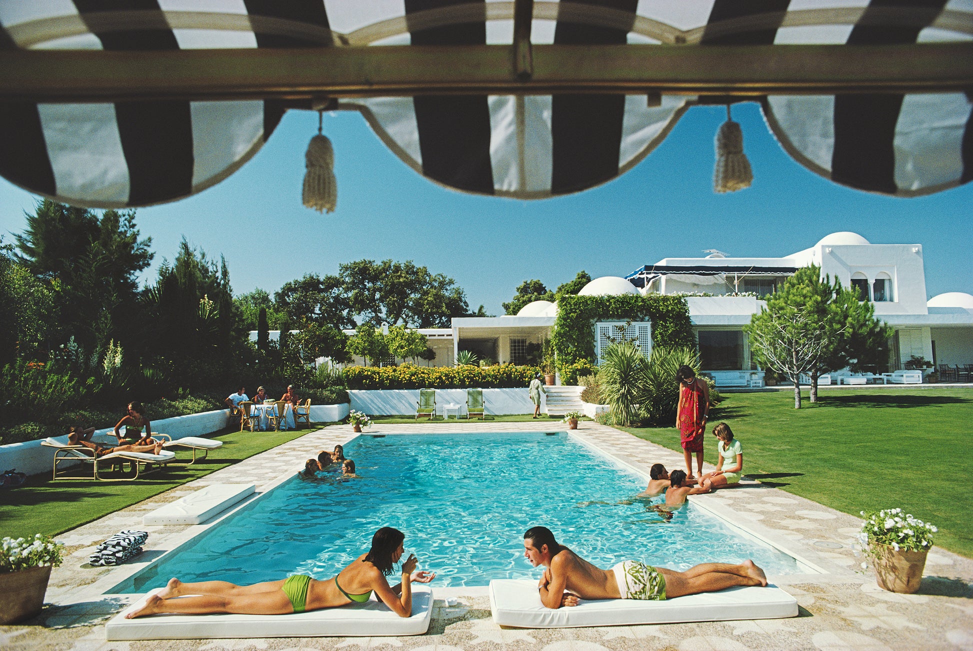 Poolside in Sotogrande by Slim Aarons, Mediterranean fine art photograph printed on matte archival paper from Getty Images (asset #2639118). Available from The Picturalist for luxury interiors