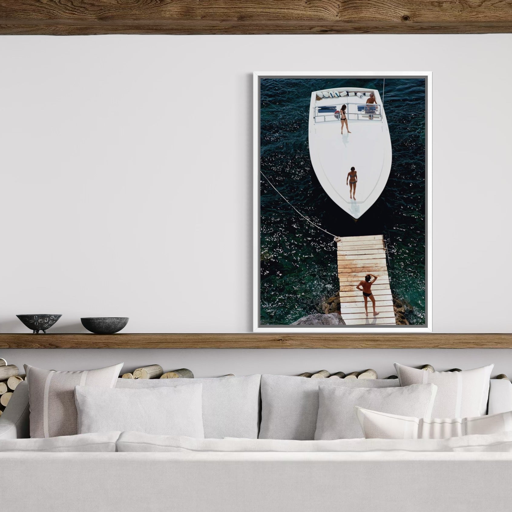 Framed artwork of a boat and people on a wall above a sofa.