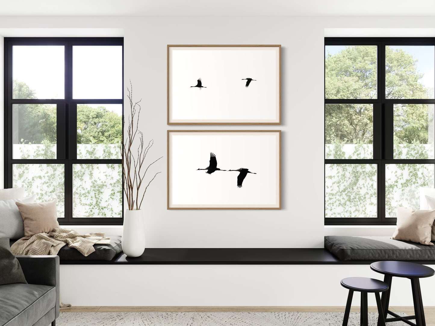 Living room with framed artwork of birds on a white wall, large windows, and modern furniture.