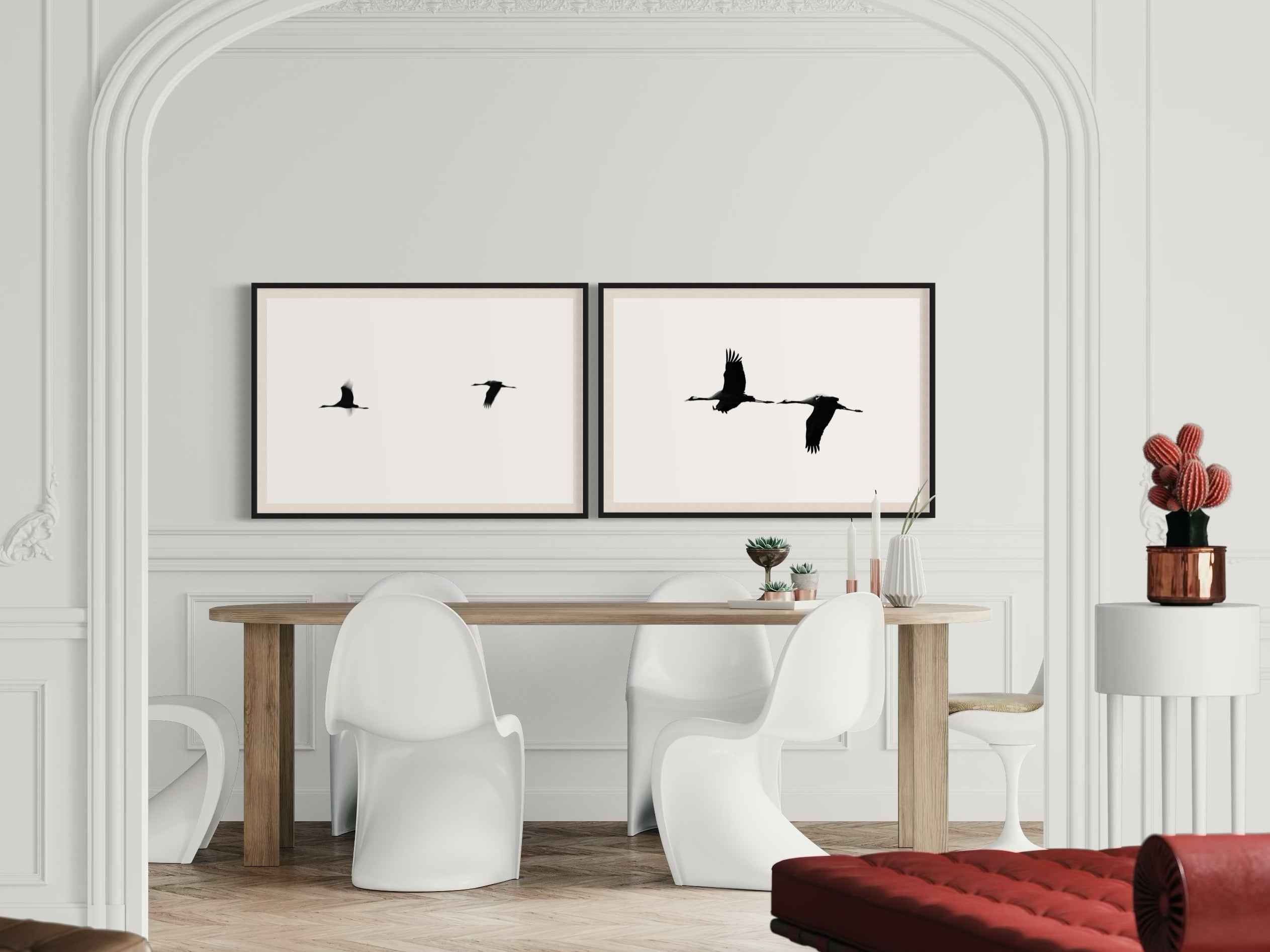 Modern interior with a dining table and chairs, framed black and white artworks on the wall.