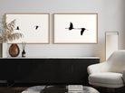 Two framed prints of birds on a wall above a console table in a living room.