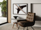 Modern interior with a brown leather chair, side table, and abstract art on the wall.