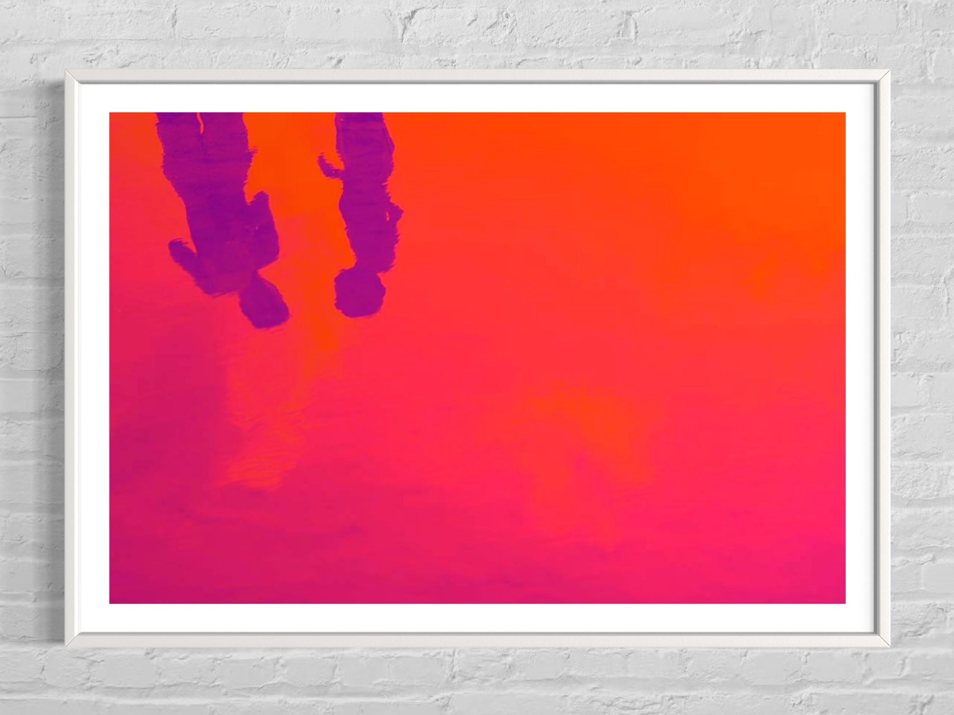 Framed artwork with a pink and orange gradient background and silhouettes of two people.