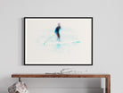 Framed artwork of a skier on a white background, displayed above a wooden console table.