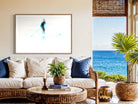 Living room with a view of the ocean, featuring a sofa, coffee table, and decorative items.
