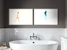 Modern bathroom with a freestanding bathtub, white tiles, and abstract art on the wall.