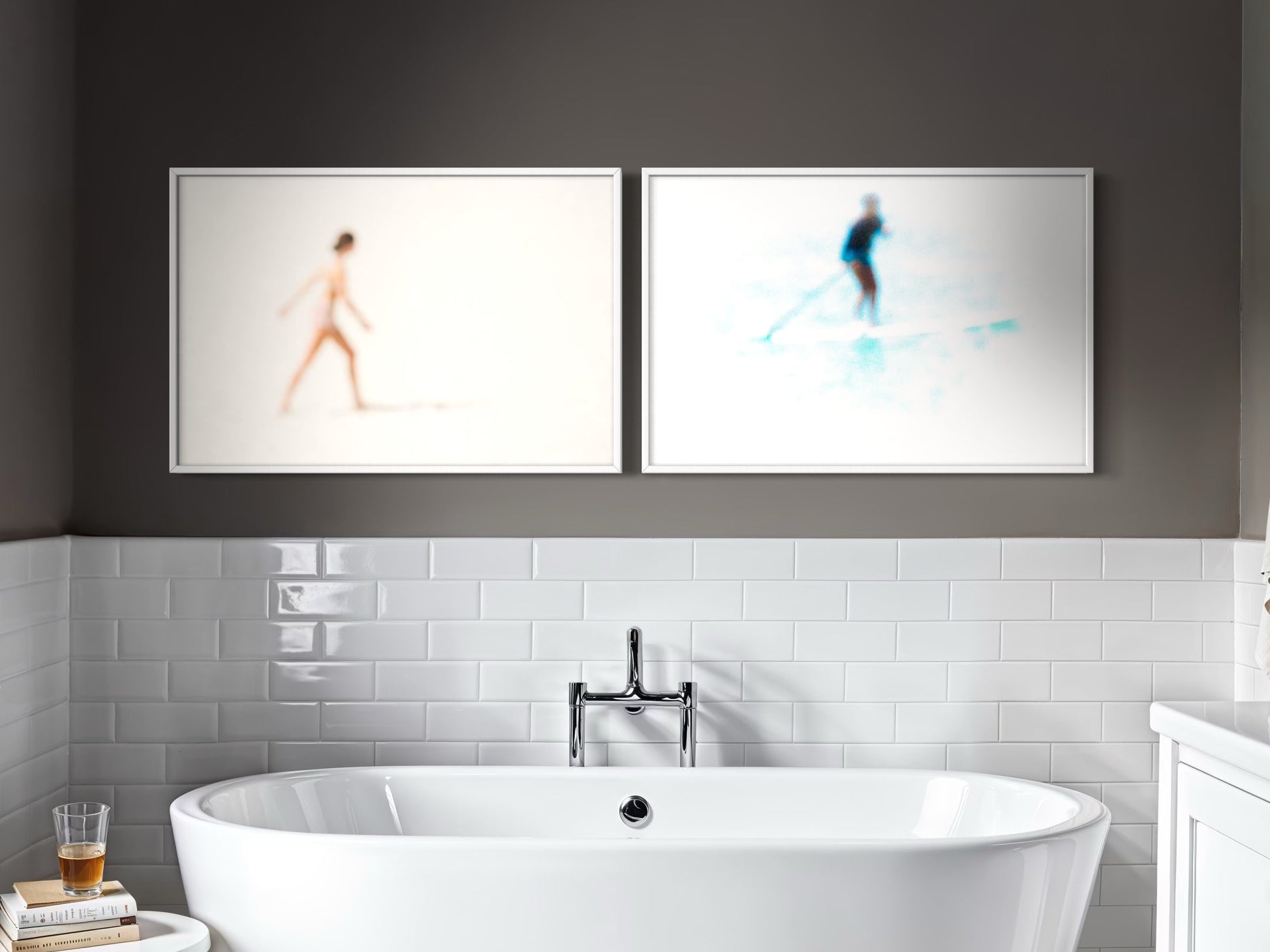 Modern bathroom with a freestanding bathtub, white tiles, and abstract art on the wall.