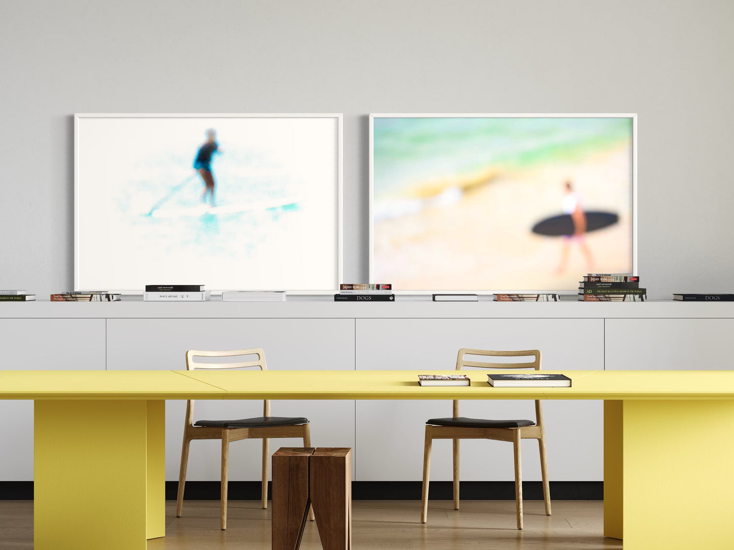 Modern office setup with yellow desk, chairs, and two large monitors on a gray wall.