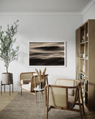 Modern living room with wicker chairs, a plant, and abstract art on the wall.