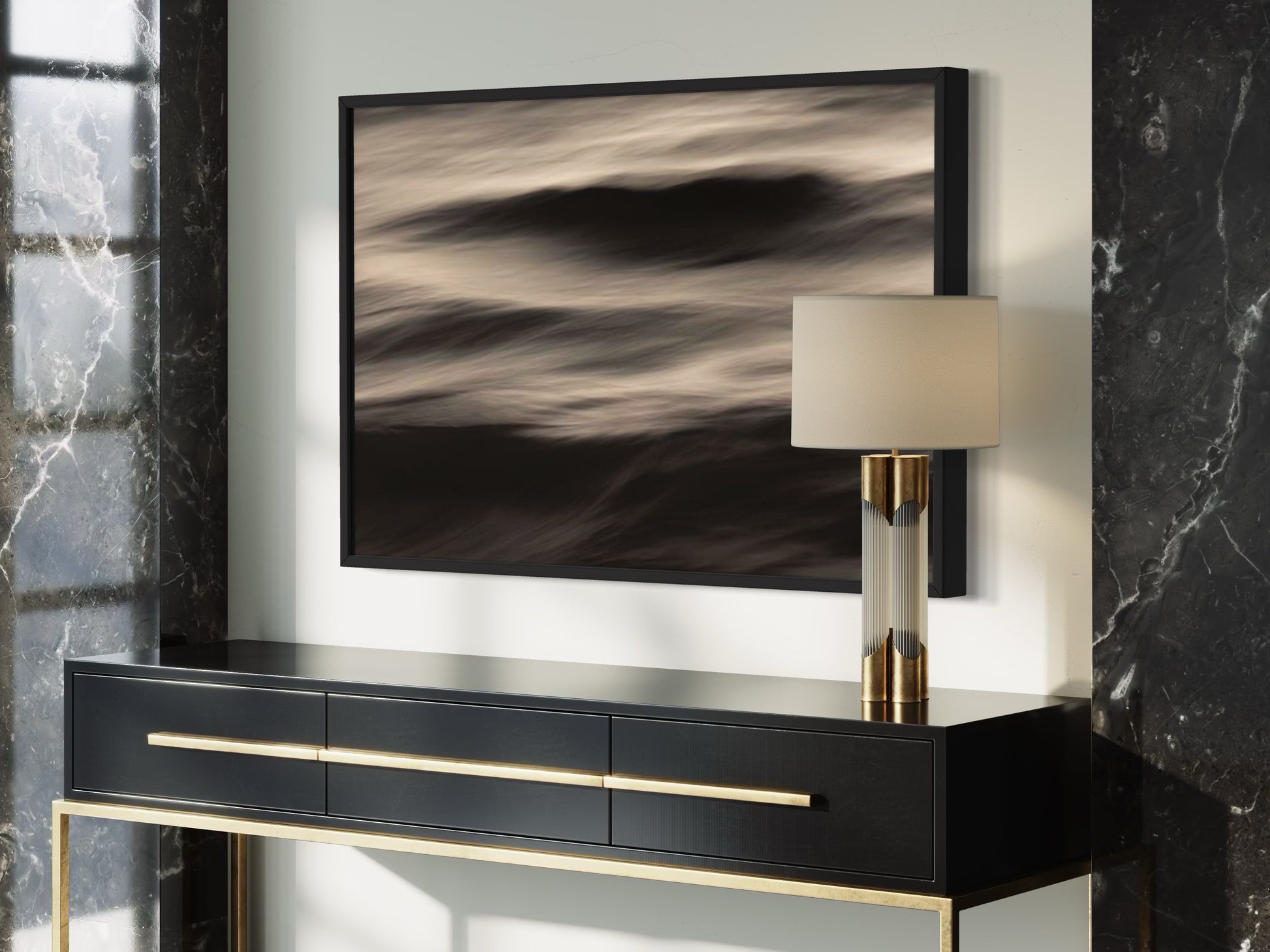 Modern black console table with gold accents against a marble wall.