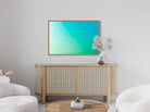 Modern living room with a wooden sideboard, white chairs, and a television displaying a green and turquoise gradient.