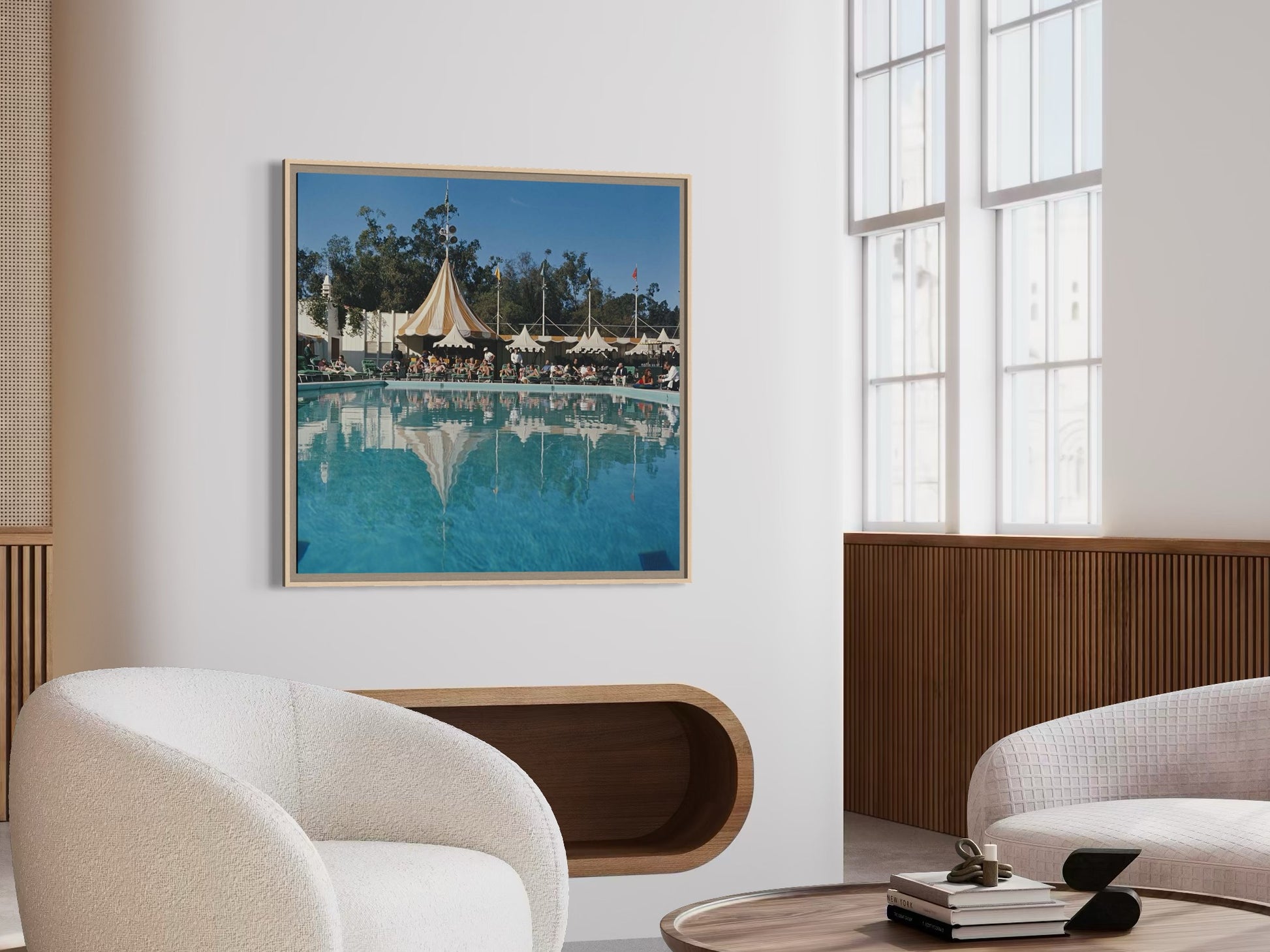 Modern living room with a framed photograph of a poolside scene on the wall.